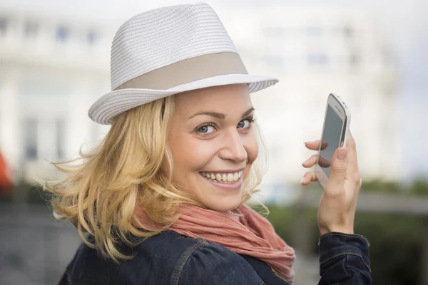 Ung kvinna med en smartphone i staden — Stockfoto