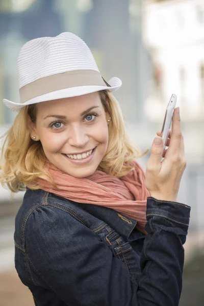 Ung kvinna med en smartphone i staden — Stockfoto