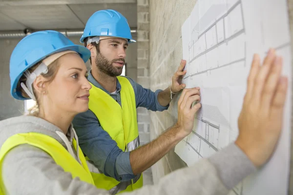 Engineers on building site checking plans — Stock Photo, Image