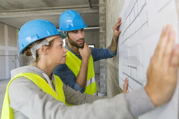 Engineers on building site checking plans — Stock Photo, Image