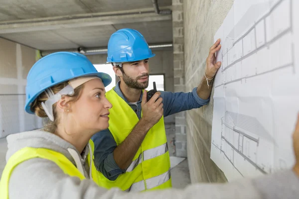 Engineers on building site checking plans — Stock Photo, Image