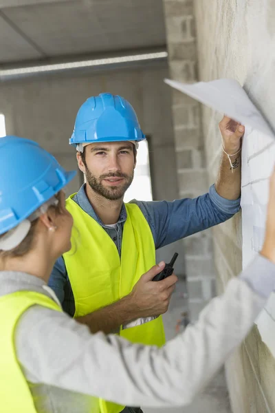 Engineers on building site checking plans — Stock Photo, Image