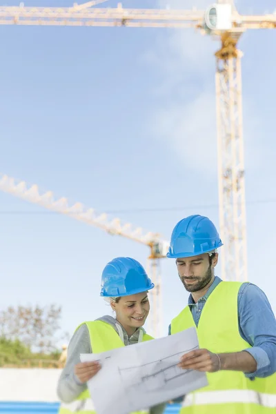 Engineers on building site checking plans — Stock Photo, Image