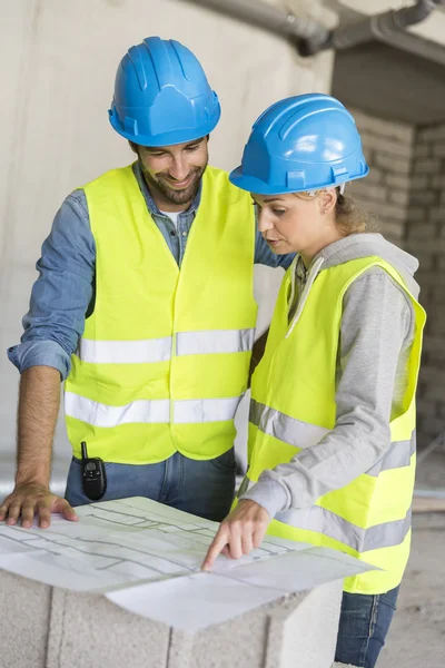 Engineers on building site checking plans — Stock Photo, Image