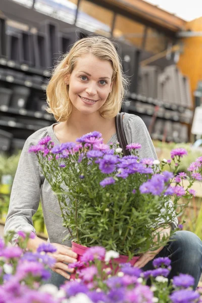 Jovem mulher escolhendo flores no centro do jardim — Fotografia de Stock