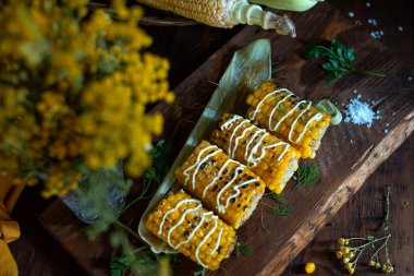 Soslu taze mısır koçanı ve ahşap kaplamalı kişniş. Sağlıklı vejetaryen yemekleri. Üst görünüm. 