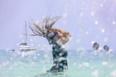 Yazın denizde oynayan Asyalı kadınlar. Deniz suyunda ıslak saçlı bir kadın. Taze yaz ıslak kumsalda görünüyor..