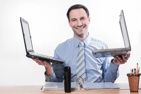 Empresário sorridente segurando laptops — Fotografia de Stock