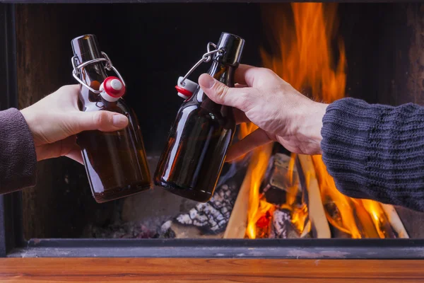 Happy couple cheering with beer bottles at skiing hut — Stock Photo, Image