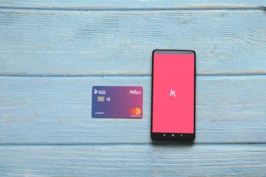 Brezilya, SP - 30 Ağustos 2021: Mobil cihazın ekranında Meliuz logosu ve mavi ahşap arka planda Meliuz kartı. Meliuz, Brezilya 'da nakit para yatırımı üzerine kurulmuş bir girişim.