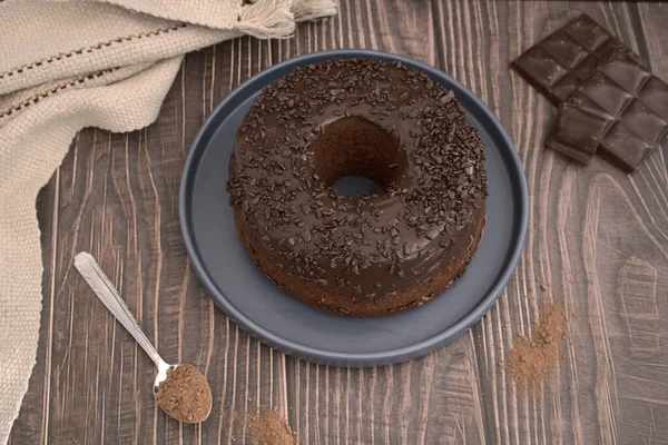 Üst Manzara. Ahşap arka planda ev yapımı çikolatalı kek, yanında da çikolata parçaları.
