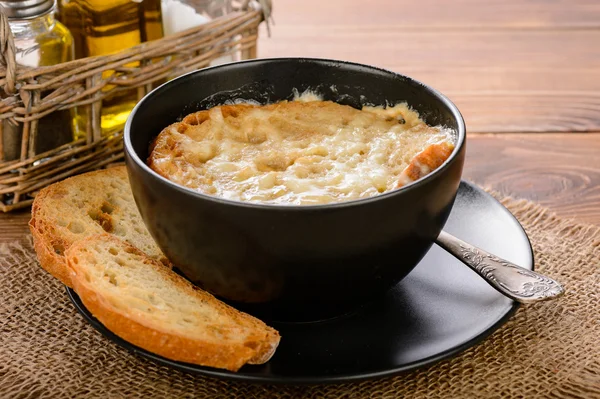 Французский луковый суп с тостами на деревянном столе . — стоковое фото