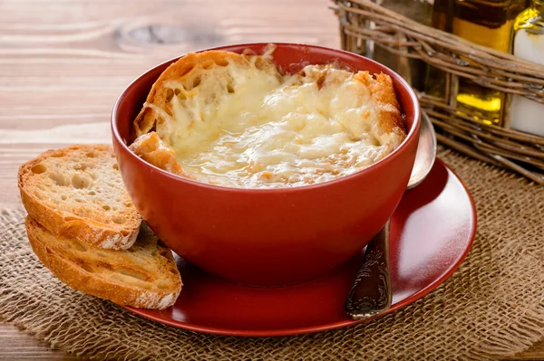 Французский луковый суп с тостами на деревянном столе . — стоковое фото