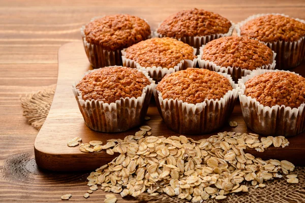 Βρώμης muffins σχετικά με καφέ ξύλινη σανίδα. — Φωτογραφία Αρχείου