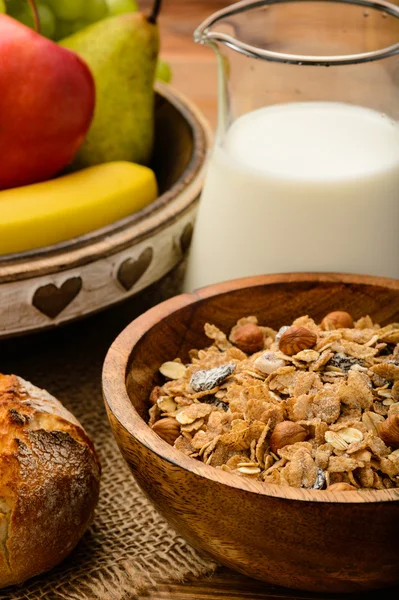 Здоровый завтрак с мюсли, молоком, свежими фруктами и орехами . Стоковое Фото