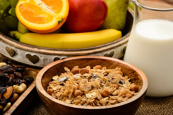Здоровый завтрак с мюсли, молоком, свежими фруктами и орехами . Стоковая Картинка