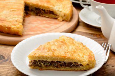 Ahşap masa kıyılmış etli turta.