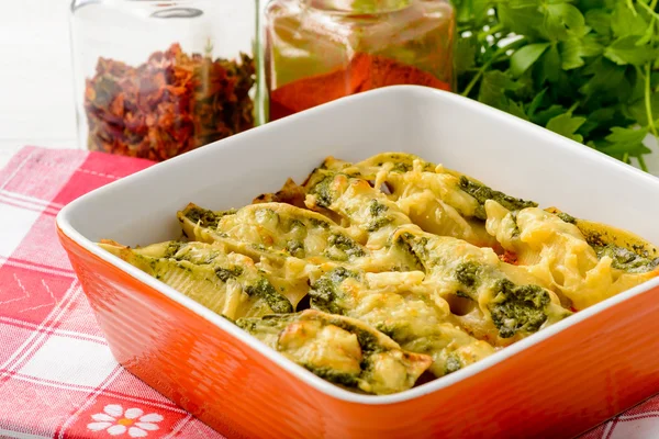 Итальянская кухня - паста раковины фаршированные шпинатом, рикотта и запеченные с помидорами — стоковое фото