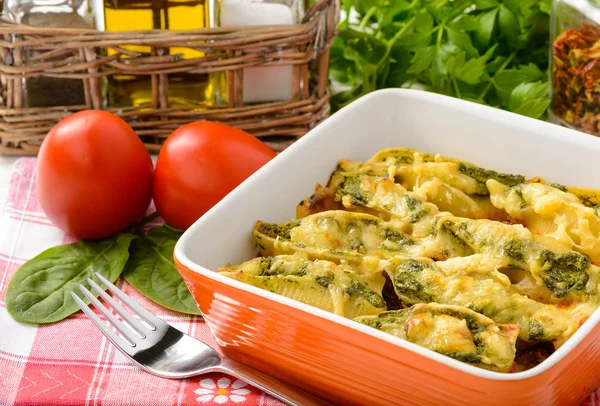 Cucina italiana - involucri di pasta ripieni di spinaci, ricotta e al forno con pomodoro — Foto Stock