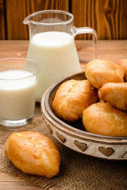 Geleneksel Rus pasta piroşkim ve ahşap masa üzerinde süt.