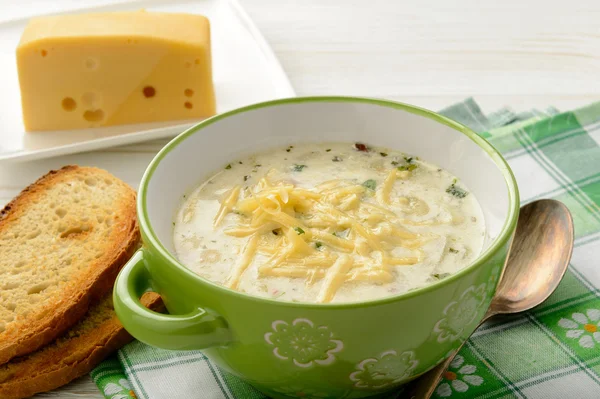 白い木製のテーブルにチーズとジャガイモのスープ. — ストック写真