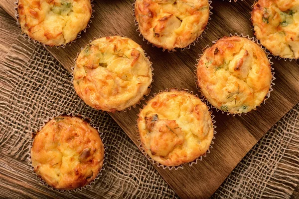 Hausgemachte Muffins mit Huhn und Käse auf braunem Holzbrett. — Stockfoto