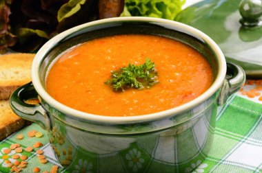 Ahşap masa üzerinde kırmızı mercimek krem çorbası.