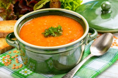 Ahşap masa üzerinde kırmızı mercimek krem çorbası.