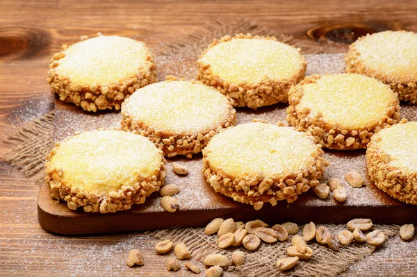 Galletas de mantequilla (alfajores) con caramelo y maní sobre fondo de madera . — Foto de Stock