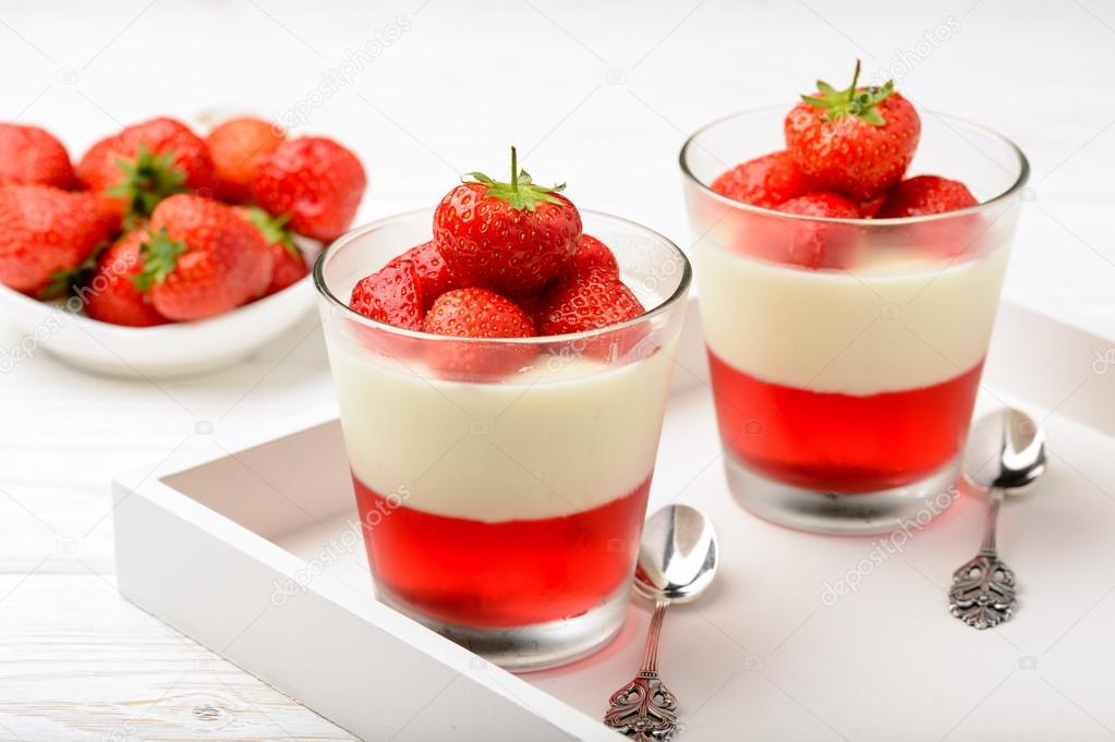 Layered strawberry dessert - panna cotta with strawberry jelly and strawberries.
