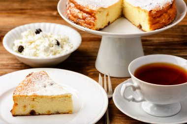 Peynirli kek dilimi ve ahşap arka plan üzerinde çay.