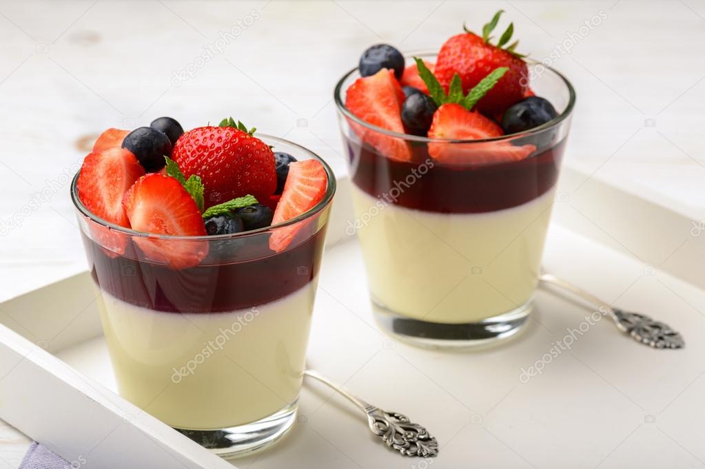 Layered strawberry dessert - panna cotta with berry jelly, blueberries and strawberries.