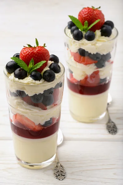 Layered strawberry dessert - panna cotta with berry jelly, blueberries and strawberries. — Stock Photo, Image