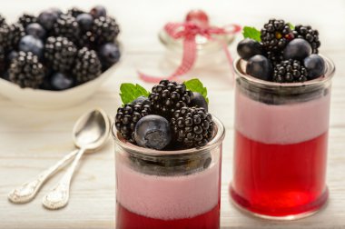 Berry jöle köpük Beyaz ahşap zemin üzerinde bir yaban mersini ve böğürtlen ile.