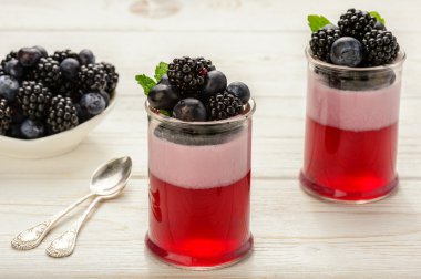 Berry jöle köpük Beyaz ahşap zemin üzerinde bir yaban mersini ve böğürtlen ile.