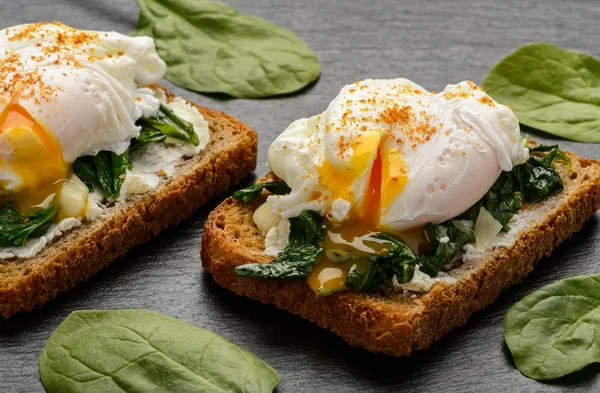 Υγιεινό πρωινό - σάντουιτς με τυρί κρέμα και σπανάκι, αυγό ποσέ. — Φωτογραφία Αρχείου