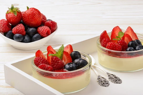 Creme brulee in glass bowls with strawberries, raspberries and blueberries. — Stock Photo, Image