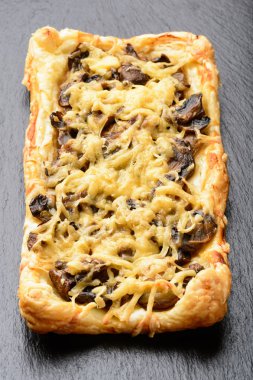 Mantar ve peynir siyah arka plan üzerine puf hamur işleri.