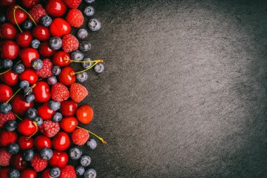 Siyah arka plan üzerine yaz meyveleri (böğürtlen, ahududu ve kiraz). Metin için kullanılan.