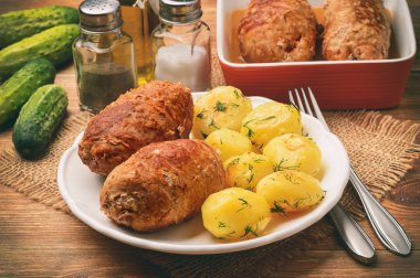 Fırında patates ile kavrulmuş et roulades sereved. Ahşap arka plan üzerinde.