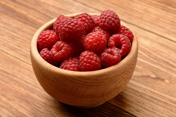 Ripe raspberries in wooden bowl. Close-up. — Stock Photo, Image