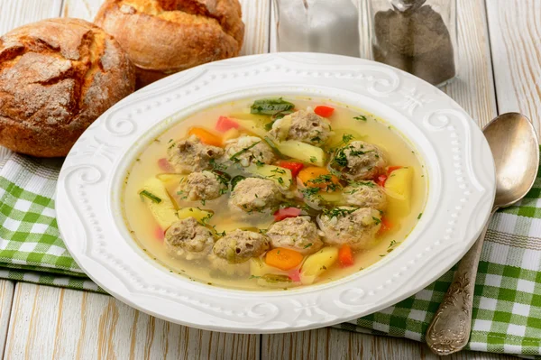 Sopa con albóndigas sobre fondo de madera blanca . — Foto de Stock