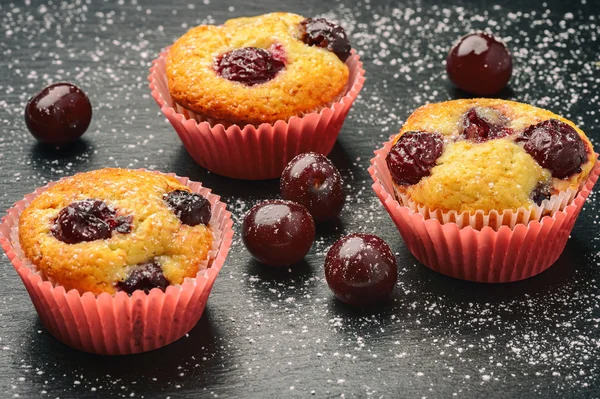 Muffins de cereja no fundo preto . — Fotografia de Stock