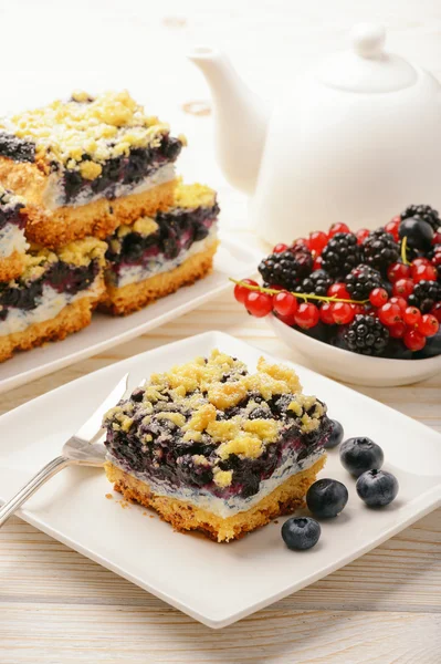 Un pedazo de pastel de galletas con arándanos. Sobre mesa de madera blanca . — Foto de Stock