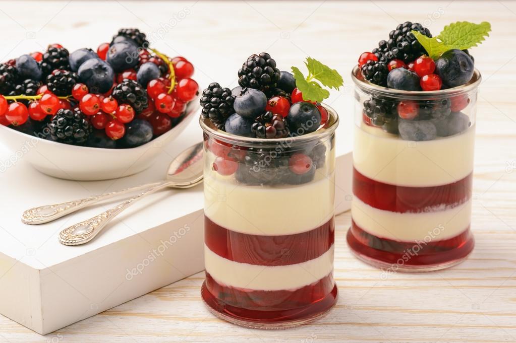 Layered berry dessert - panna cotta with berry jelly, blueberries,blackberries and red currants.
