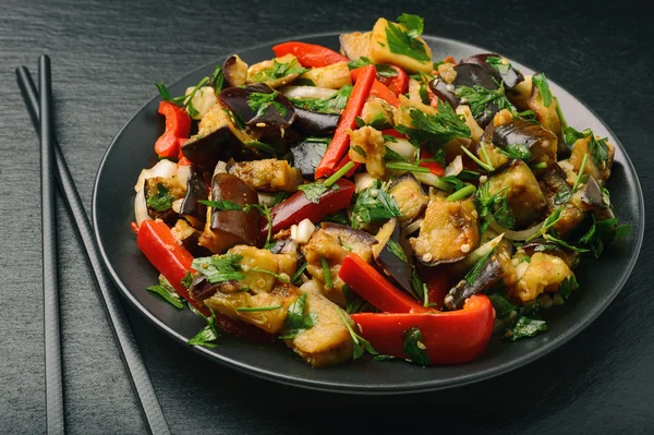 Appetizer - asian salad with eggplants, paprika and garlic on black background. — Stock Photo, Image