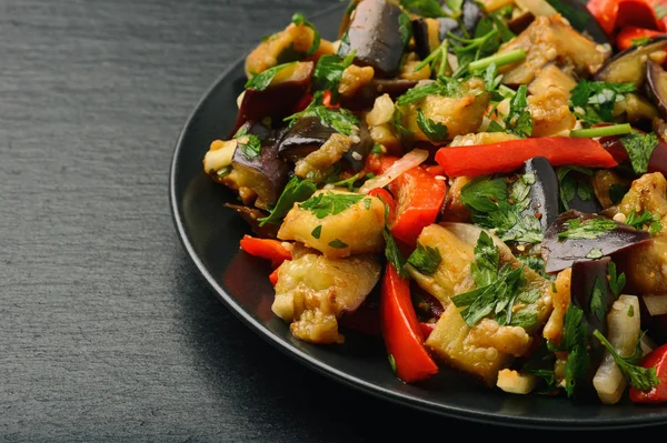 Appetizer - asian salad with eggplants, paprika and garlic on black background. — Stock Photo, Image