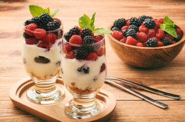 Müsli, ahududu ve böğürtlen ile sağlıklı yoğurt tatlısı .