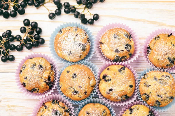 Söta muffins med aroniabär (aronia) på vitt trä bord. — Stockfoto