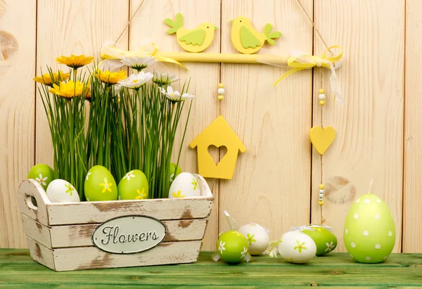 Osterdekoration - Holzkiste mit Blumen und Eiern auf dem Holzgrund. — Stockfoto